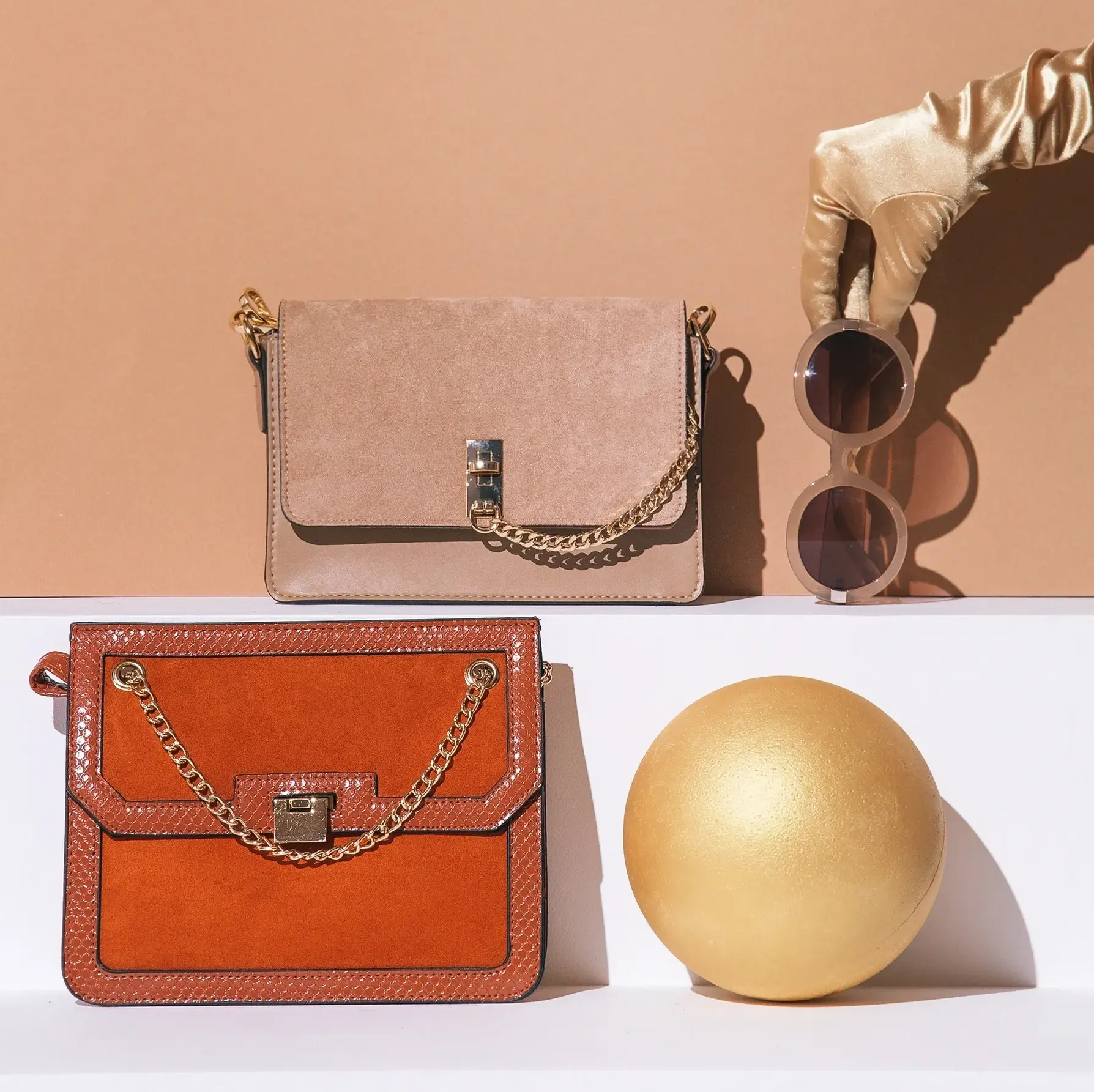 Handbags, sunglasses, and a gold decorative sphere.