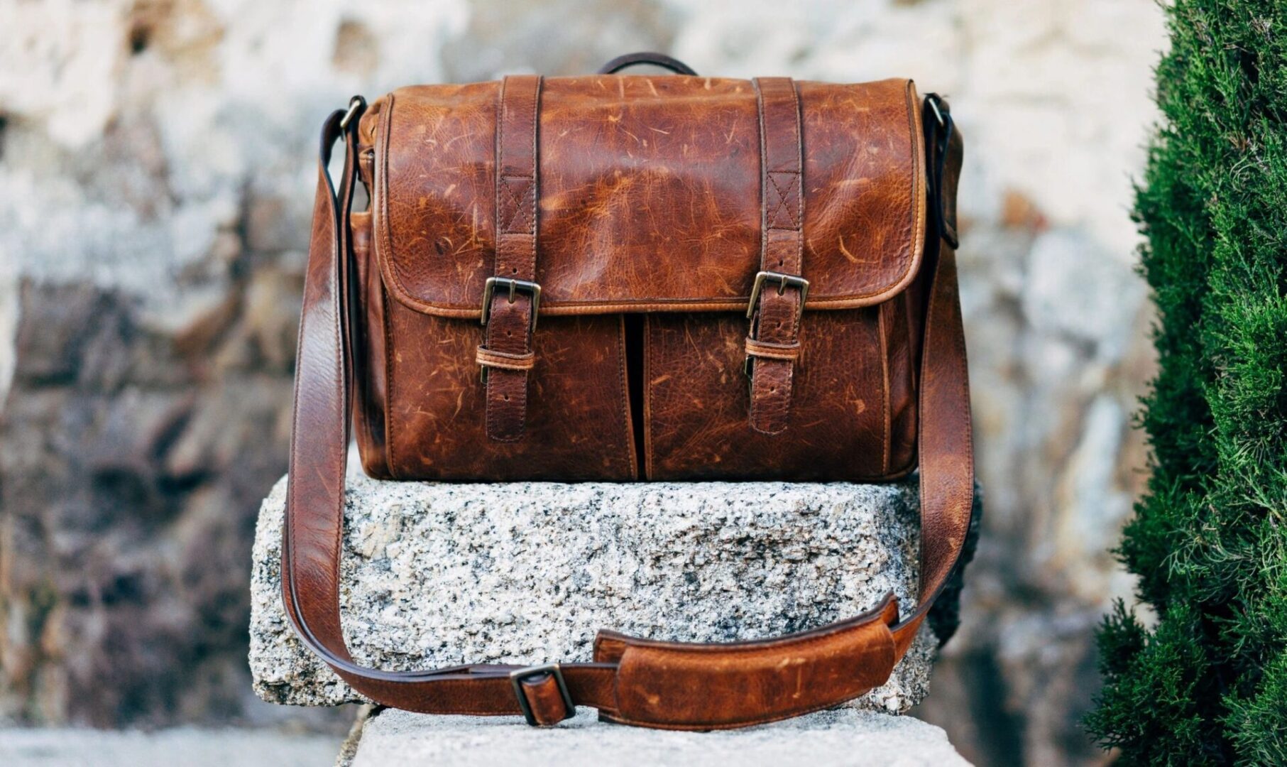 Brown leather satchel on stone surface.